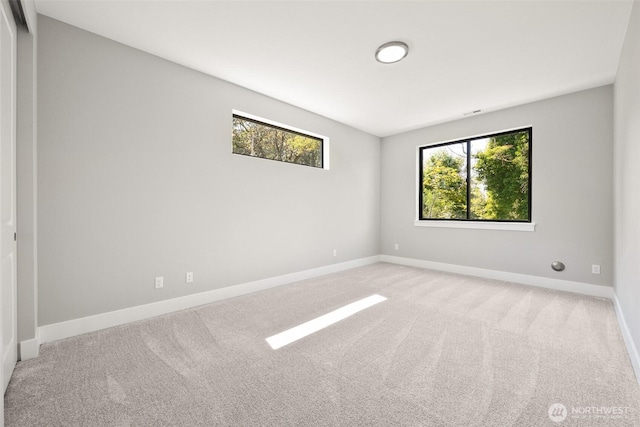 spare room with carpet floors, baseboards, and healthy amount of natural light