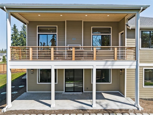 rear view of property featuring a balcony and a patio area