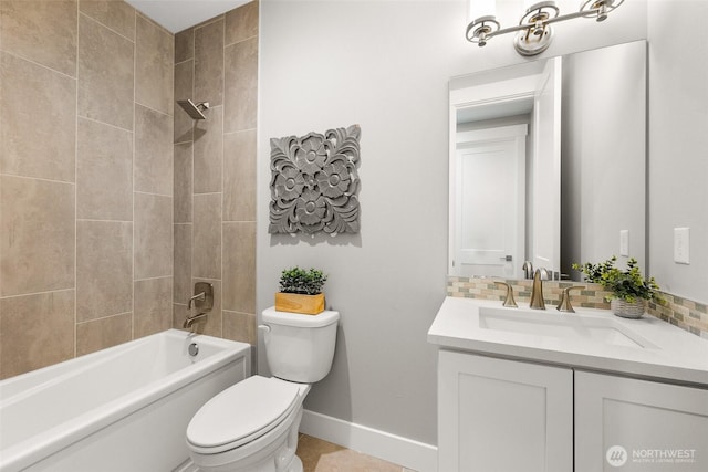 bathroom with baseboards, toilet, bathing tub / shower combination, vanity, and decorative backsplash