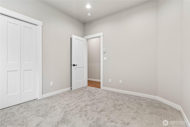 unfurnished bedroom with carpet floors, baseboards, a closet, and recessed lighting