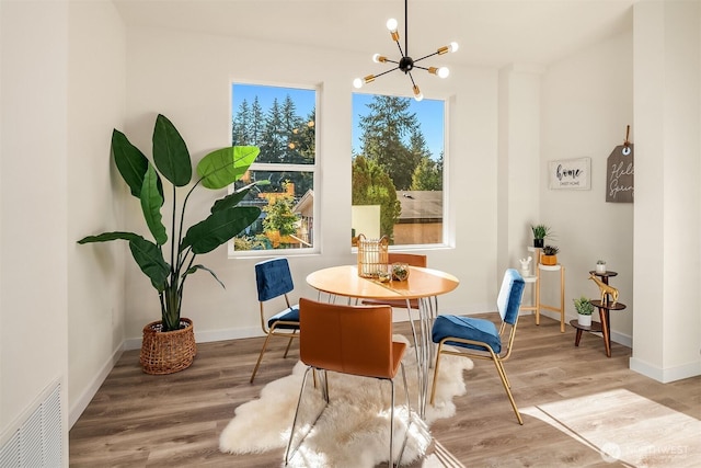dining area featuring a chandelier, wood finished floors, and baseboards