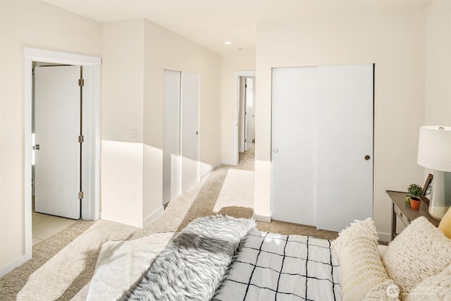 bedroom featuring light carpet and baseboards
