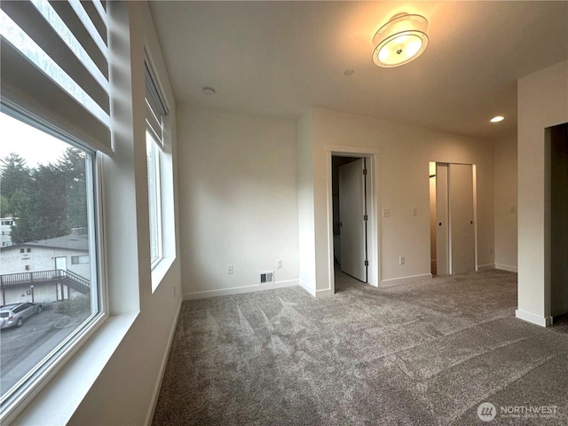 carpeted spare room with plenty of natural light, baseboards, and recessed lighting