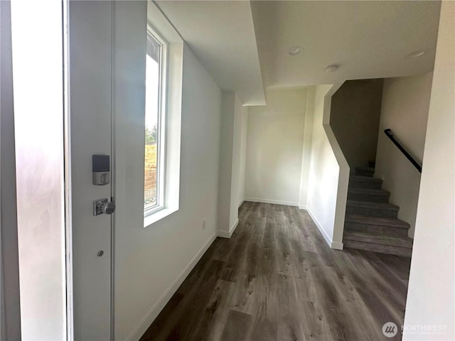 hall featuring wood finished floors, baseboards, and stairway