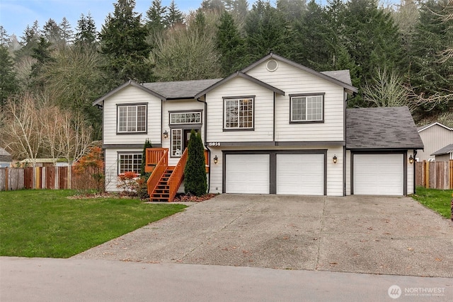 split foyer home with driveway, a garage, a shingled roof, and stairway