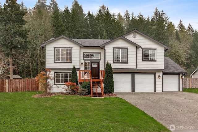 raised ranch featuring an attached garage, driveway, and roof with shingles