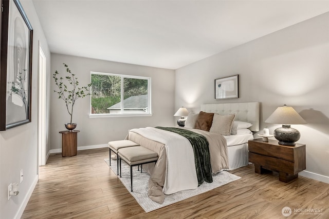 bedroom with baseboards and wood finished floors