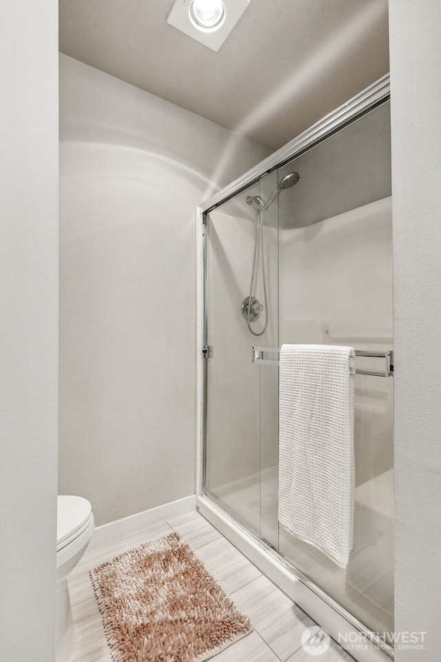 full bathroom featuring a shower stall and toilet