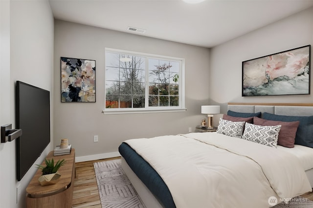 bedroom featuring light wood-style floors and baseboards