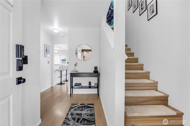 stairs featuring wood finished floors and baseboards