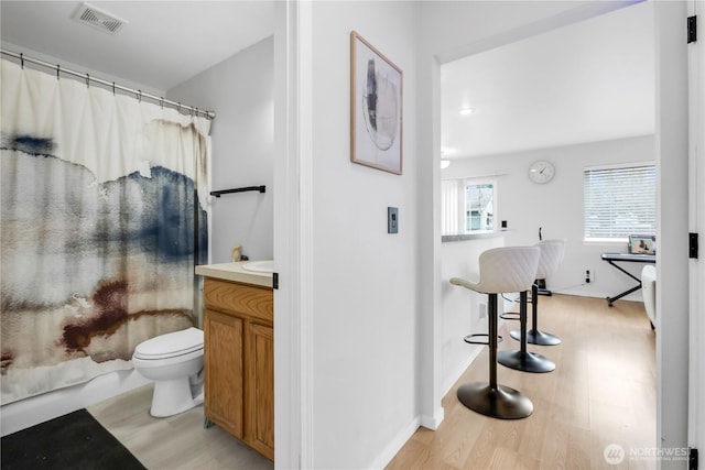 bathroom featuring wood finished floors, toilet, and vanity