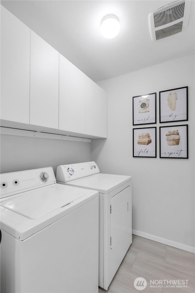 laundry room with washer and dryer, cabinet space, and baseboards