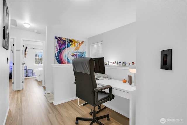 home office featuring light wood finished floors and baseboards