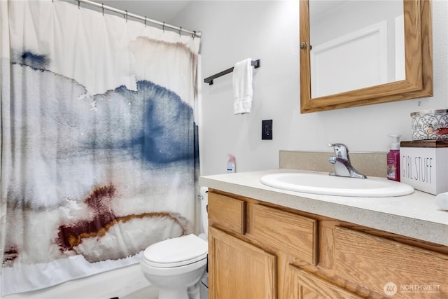 bathroom featuring curtained shower, vanity, and toilet