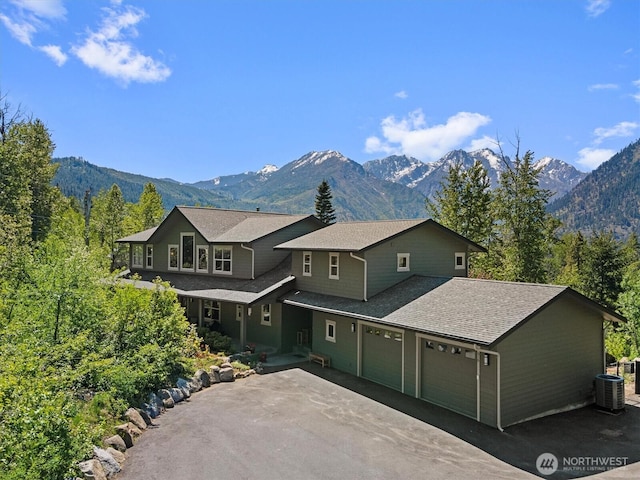 510 Dempsey Rd, Leavenworth, WA 98826 - view of front facade with a garage, driveway, a mountain view, and central AC