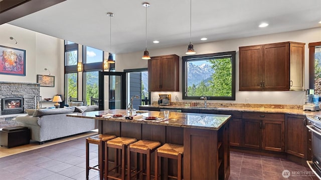 510 Dempsey Rd, Leavenworth, WA 98826 - kitchen with dark tile patterned floors, light stone countertops, a sink, open floor plan, and a breakfast bar