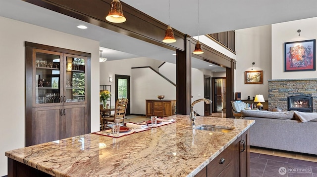510 Dempsey Rd, Leavenworth, WA 98826 - kitchen featuring a sink, open floor plan, light stone counters, dark brown cabinets, and hanging light fixtures