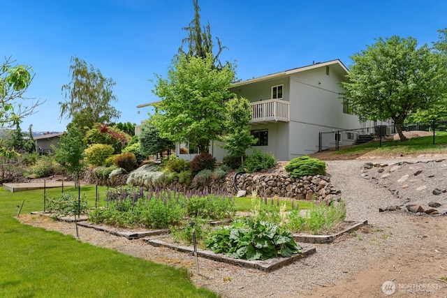 view of yard with a vegetable garden and a balcony