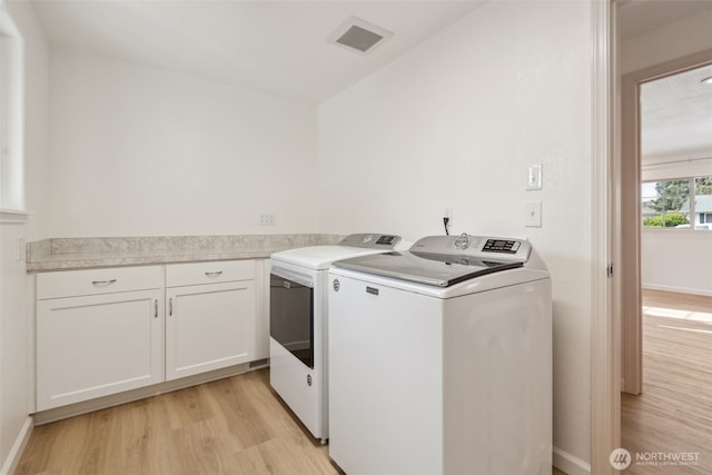 133 Bradley St, Walla Walla, WA 99362 - clothes washing area with washing machine and clothes dryer, light wood-type flooring, and cabinet space