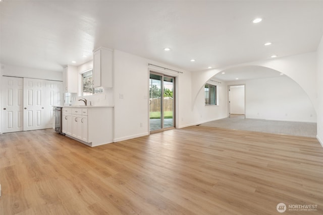 133 Bradley St, Walla Walla, WA 99362 - unfurnished living room featuring arched walkways, recessed lighting, light wood-type flooring, plenty of natural light, and baseboards