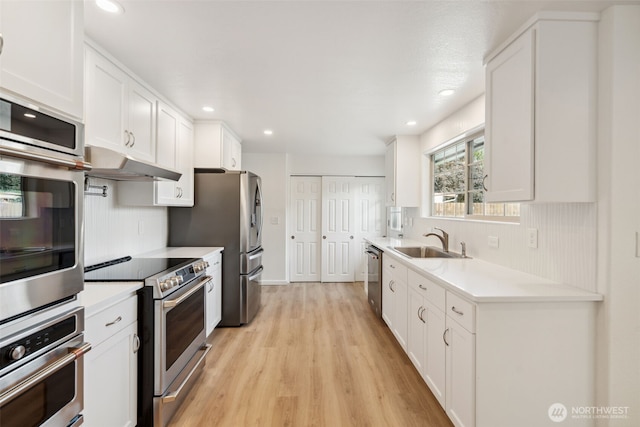 133 Bradley St, Walla Walla, WA 99362 - kitchen with appliances with stainless steel finishes, a sink, light wood-style flooring, white cabinetry, and recessed lighting