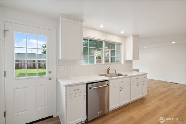 133 Bradley St, Walla Walla, WA 99362 - kitchen with stainless steel dishwasher, a sink, white cabinetry, light wood-type flooring, and recessed lighting