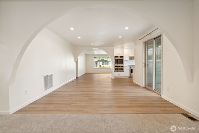 133 Bradley St, Walla Walla, WA 99362 - unfurnished living room with recessed lighting, light wood-style floors, baseboards, and arched walkways