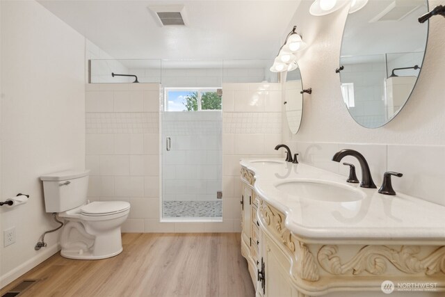 133 Bradley St, Walla Walla, WA 99362 - full bathroom with wood finished floors, a tile shower, toilet, and double vanity