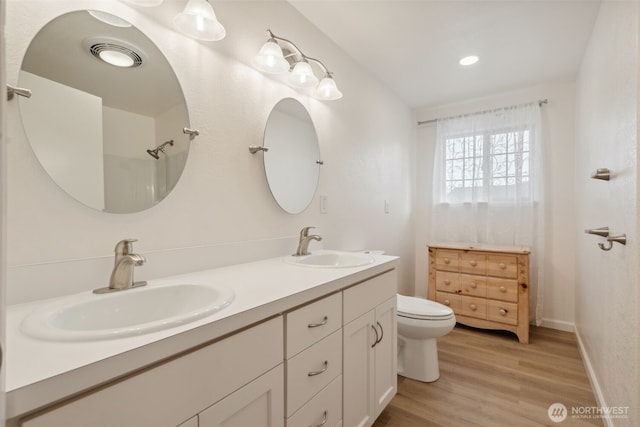 133 Bradley St, Walla Walla, WA 99362 - bathroom with wood finished floors, toilet, double vanity, and recessed lighting