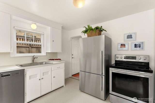 kitchen featuring stainless steel appliances, a sink, white cabinetry, and light countertops