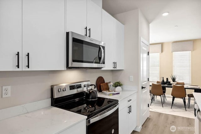 14707 87th Ave SE Unit U8, Snohomish, WA 98296 - kitchen with stainless steel microwave, electric range, white cabinetry, and light wood finished floors