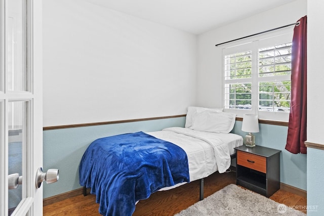 bedroom featuring wood finished floors and baseboards