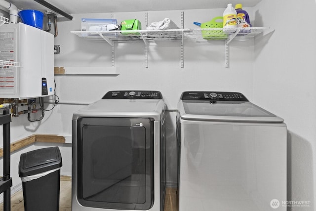 clothes washing area featuring water heater and independent washer and dryer