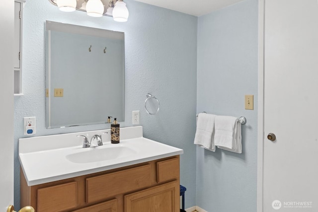 bathroom featuring vanity and a textured wall