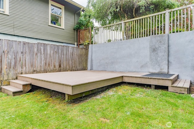 wooden deck featuring a lawn