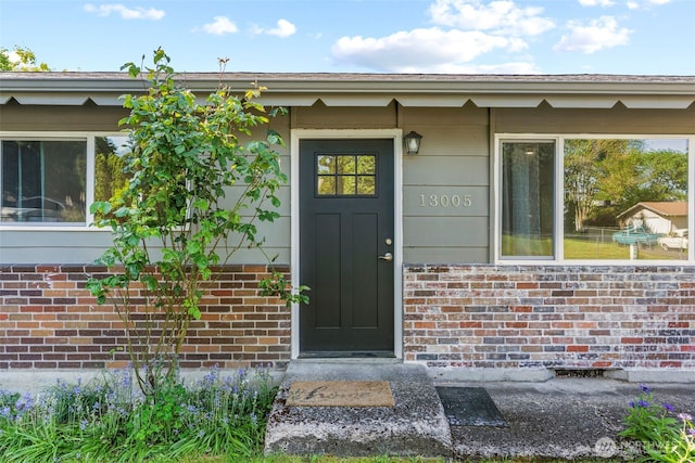 doorway to property with brick siding