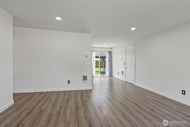 unfurnished room with wood finished floors, recessed lighting, and baseboards