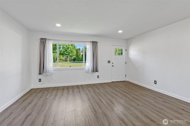 unfurnished room with wood finished floors, healthy amount of natural light, baseboards, and recessed lighting