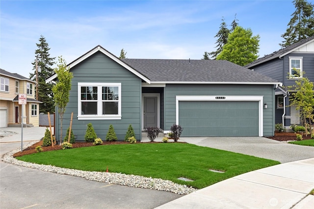 28307 74th Dr NW Unit 90, Stanwood, WA 98292 - view of front of property with a garage, concrete driveway, a front yard, and roof with shingles