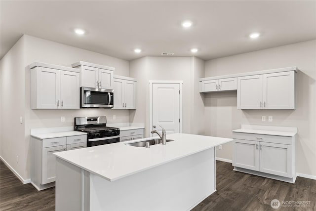 28307 74th Dr NW Unit 90, Stanwood, WA 98292 - kitchen with appliances with stainless steel finishes, dark wood-style flooring, a center island with sink, recessed lighting, and light countertops