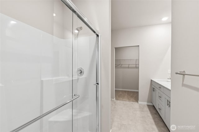 28307 74th Dr NW Unit 90, Stanwood, WA 98292 - bathroom featuring a stall shower, vanity, a walk in closet, and recessed lighting
