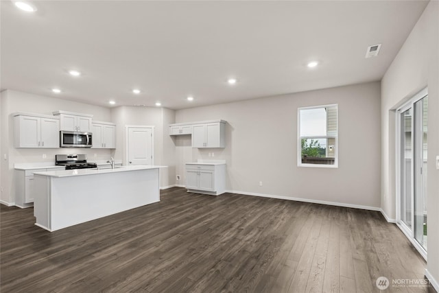 28307 74th Dr NW Unit 90, Stanwood, WA 98292 - kitchen with appliances with stainless steel finishes, dark wood-style floors, recessed lighting, a kitchen island with sink, and white cabinets