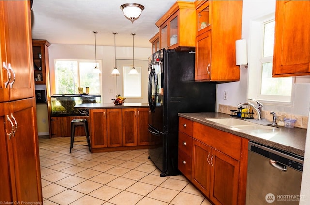 1803 Juniper St, Oroville, WA 98844 - kitchen featuring dishwasher, a sink, dark countertops, light tile patterned floors, and hanging light fixtures