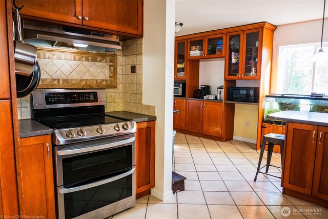 1803 Juniper St, Oroville, WA 98844 - kitchen with range with two ovens, under cabinet range hood, dark countertops, and black microwave