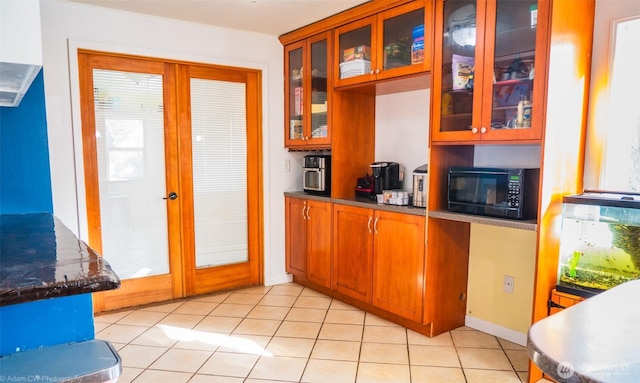 1803 Juniper St, Oroville, WA 98844 - kitchen featuring black microwave, glass insert cabinets, brown cabinetry, and light tile patterned floors