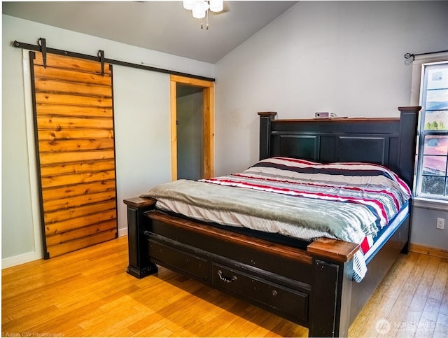 1803 Juniper St, Oroville, WA 98844 - bedroom with lofted ceiling, light wood-type flooring, a barn door, and baseboards
