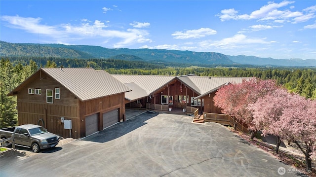 2262 Lambert Rd, Cle Elum, WA 98922 - view of front of home featuring a mountain view, metal roof, driveway, an attached garage, and a standing seam roof