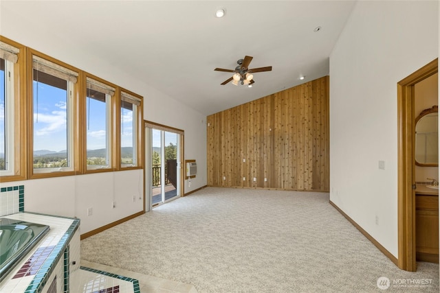 2262 Lambert Rd, Cle Elum, WA 98922 - unfurnished living room with carpet, a ceiling fan, baseboards, vaulted ceiling, and wooden walls
