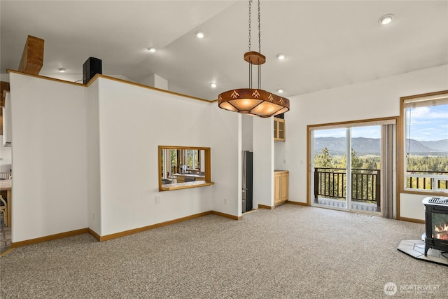 2262 Lambert Rd, Cle Elum, WA 98922 - unfurnished living room featuring light colored carpet, a wood stove, a mountain view, baseboards, and lofted ceiling