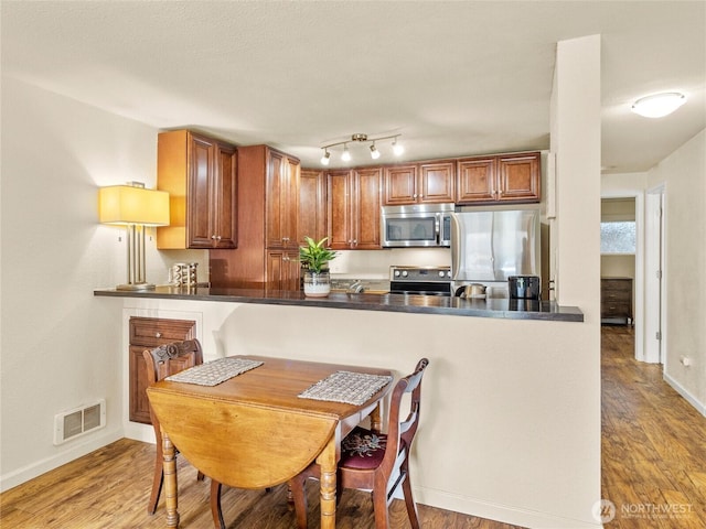 31003 14th Ave S Unit H1, Federal Way, WA 98003 - kitchen featuring appliances with stainless steel finishes, baseboards, wood finished floors, and dark countertops